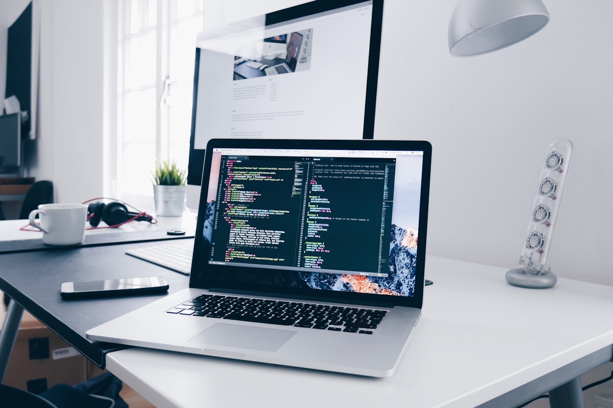 Professional software development workspace with laptop and code